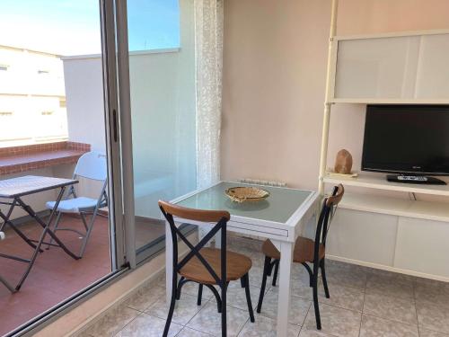 Cette chambre dispose d'une télévision et d'une table avec des chaises. dans l'établissement Confortable T2 avec terrasse privée près des Thermes et du centre-ville à Balaruc-les-Bains - FR-1-553-144, à Balaruc-les-Bains