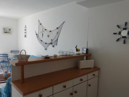 Cette chambre dispose d'une commode en bois avec un parasol sur le mur. dans l'établissement Maison à 100m de la plage avec piscine, 4 couchages, parking privé, terrasse et barbecue - FR-1-224A-40, à Bretignolles-sur-Mer