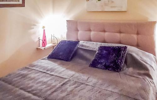 a bedroom with a bed with purple pillows on it at Gorgeous stacaravan In Epe With Wifi in Epe