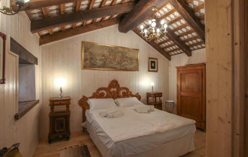 een slaapkamer met een bed en een kroonluchter bij Cozy Home In Biacis With Wifi 