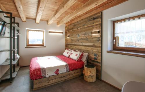 a bedroom with a bed and a wooden wall at Beautiful Home In Castello Tesino With Kitchen in Castello Tesino