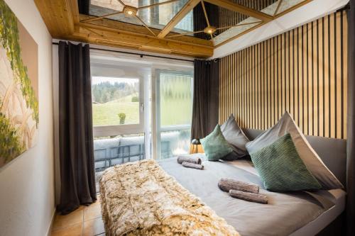 a large bed in a room with a large window at Ferienresidenz "Alpin Chic" in Bolsterlang