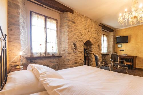 a bedroom with a bed and a stone wall at La Locanda dell'Ambra in Talamello