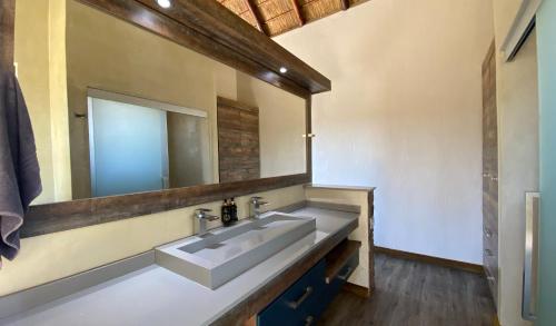a bathroom with a sink and a large mirror at Shammah lodge Mabalingwe Nature Reserve in Mabula