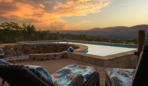 a patio with chairs and a swimming pool at Shammah lodge Mabalingwe Nature Reserve in Mabula