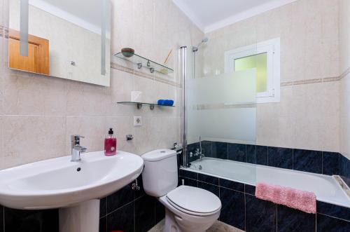 e bagno con servizi igienici, lavandino e vasca. di YourHouse Sol i Mar 2 beach apartment a Cala Mesquida