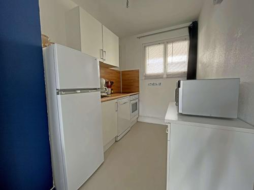  La cuisine est équipée de placards blancs et d'un réfrigérateur. dans l'établissement Studio les pieds dans l'eau à Berck-Plage avec parking privatif - FR-1-646-18, à Berck-sur-Mer