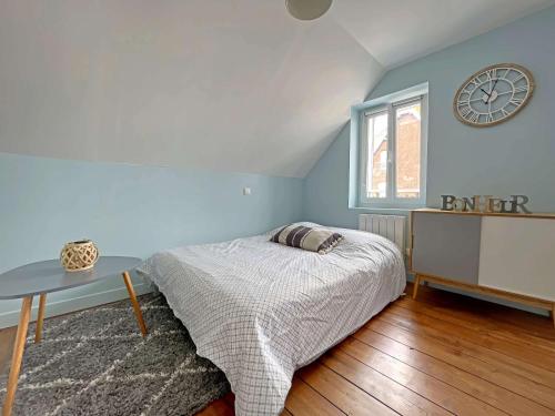 une chambre avec un lit et une horloge au mur dans l'établissement Studio rénové cœur centre-ville, tout confort avec wifi, TV et lave-linge, proche commerces - Berck - FR-1-646-15, à Berck-sur-Mer