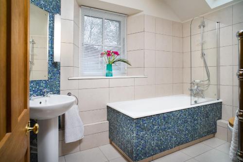a bathroom with a tub and a sink at Ty Cellin Swyddffynnon in Ystrad-Meurig