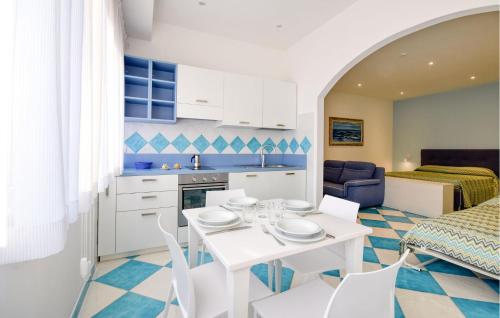 a kitchen and living room with a white table and chairs at Gorgeous Apartment In Deiva Marina in Deiva Marina