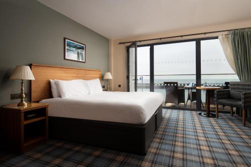 a hotel room with a bed and a large window at The Commissioners Quay Inn - The Inn Collection Group in Blythe