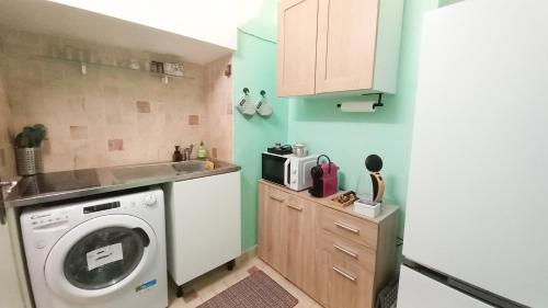 une cuisine avec une machine à laver et un évier dans l'établissement Palais Carnot central apartment with balcony and A C, à Cannes
