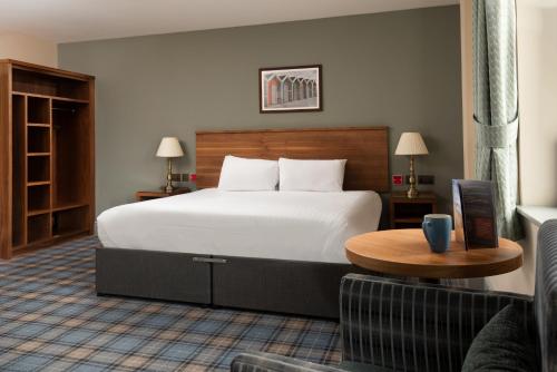 a hotel room with a large bed and a table at The Commissioners Quay Inn - The Inn Collection Group in Blythe