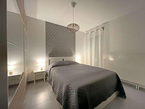 une chambre avec un lit dans une pièce blanche dans l'établissement Charmant studio pieds dans l'eau - Terrasse & Parking - Résidence récente - FR-1-646-33, à Berck-sur-Mer