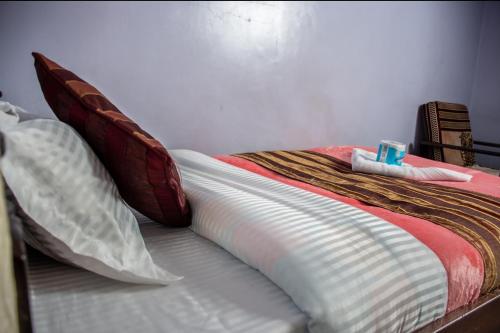 a bed with red and white sheets and pillows at ARRAHMAN HOTEL AND RESTAURANT in Nairobi