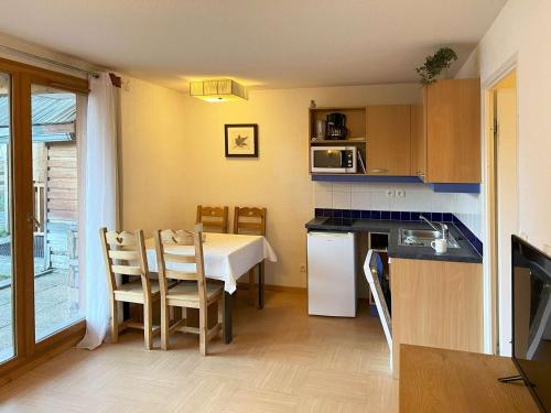 une cuisine avec une table et une salle à manger dans l'établissement Studio skis aux pieds avec piscine à 20m - FR-1-322-489, aux Orres