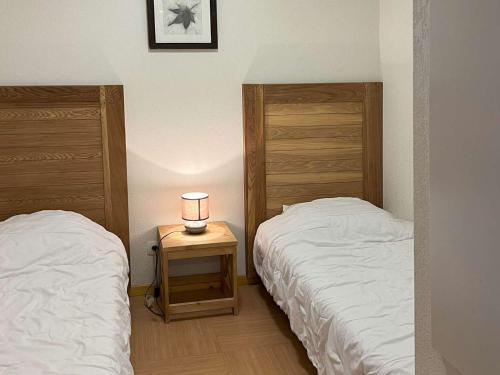 une chambre avec deux lits et une lampe sur une table dans l'établissement Studio skis aux pieds avec piscine à 20m - FR-1-322-489, aux Orres
