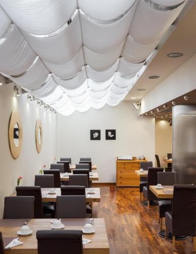 a dining room with white ceilings and tables and chairs at Acropolis Select in Athens