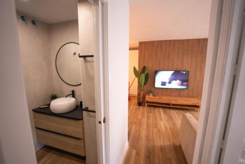 a living room with a television and a table with a vase at Apartasuites Royal Zahara, Máximo confort con vistas al mar in Zahara de los Atunes