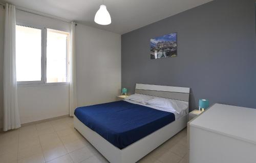 1 dormitorio con 1 cama con manta azul en Nice Apartment In Marina Di Ragusa With Kitchenette, en Marina di Ragusa