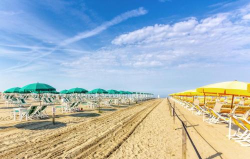 a row of umbrellas and chairs on a beach at Lovely Home In Camaiore With Wifi in Camaiore