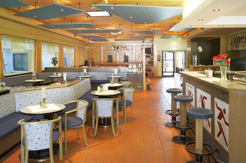 a restaurant with tables and chairs and a bar at INDOOR Camping Sportzentrum Zeltweg in Zeltweg