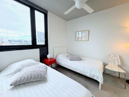 um quarto com 2 camas e uma janela em Modern Homely 2BR APT w Parking Bowen Hills em Brisbane