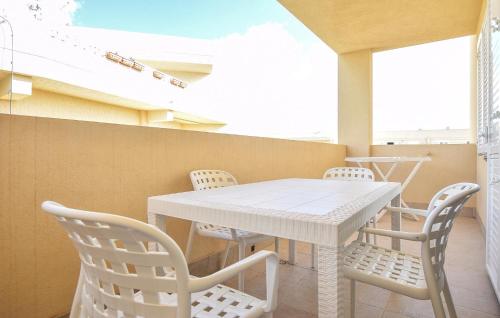 ein Esszimmer mit einem weißen Tisch und Stühlen in der Unterkunft Cozy Apartment In Marina Di Ragusa in Marina di Ragusa