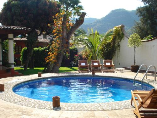 ein großer Pool mit zwei Stühlen im Hof in der Unterkunft Finca Las Palmas in Malinalco