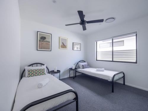 Habitación hospitalaria con 2 camas y ventana en Modern Elegance Spacious 5BR Retreat in Rochedale, en Rochedale