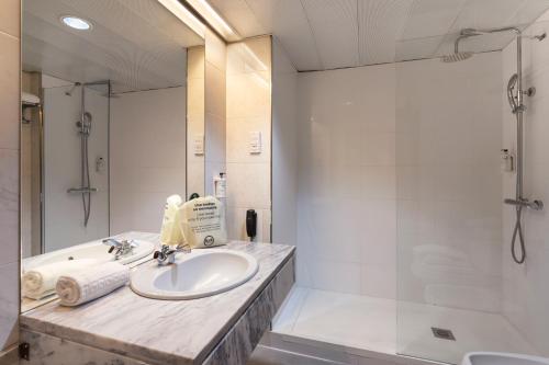 ein Badezimmer mit einem Waschbecken, einer Dusche und einer Badewanne in der Unterkunft B&B HOTEL e Apartamentos Felgueiras in Felgueiras