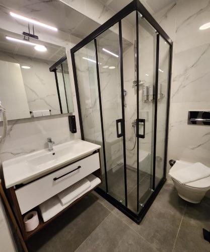 a bathroom with a shower and a sink and a toilet at Lulubay Rooms & Suites in Kusadası
