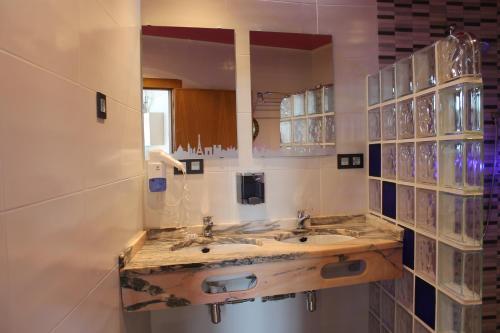 a bathroom with two sinks and a mirror at Apartamentos turísticos Vistademar in Luarca