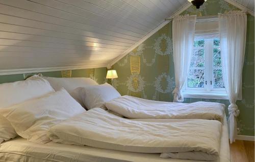 a bedroom with two beds and a window at Amazing Home In Eiksund With Kitchen 