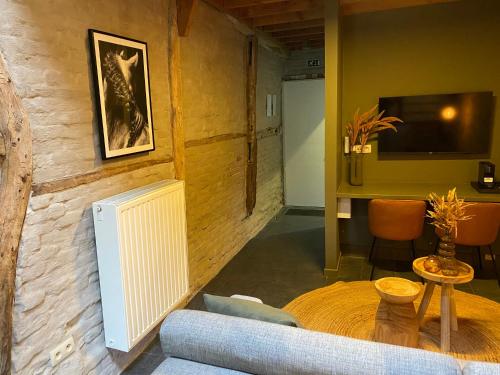 a living room with a couch and a television at Landgoed De Hoogmolen in Oudsbergen 