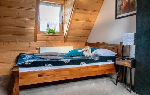 a wooden bed in a room with a window at Awesome Home In Poronin With Kitchen in Poronin