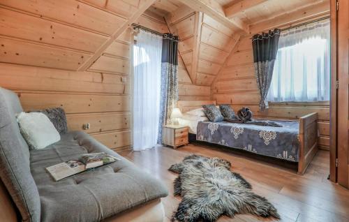 a log cabin living room with a bed and a couch at Gorgeous Home In Poronin With Wi-fi in Poronin