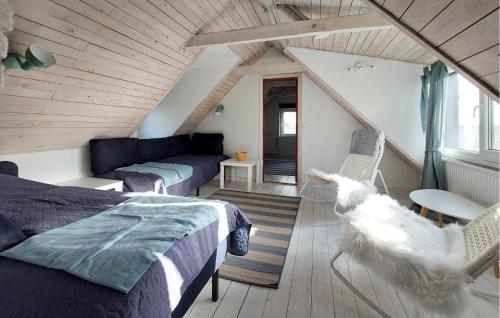 a attic room with a bed and a couch at Beautiful Home In Lddekpinge With Kitchen in Löddeköpinge