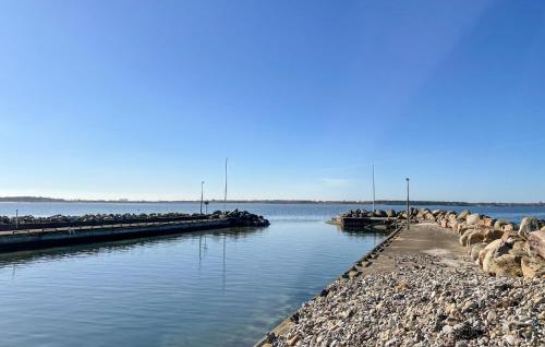 a group of rocks on the water near a dock at 2 Bedroom Cozy Home In Farhult in Farhult