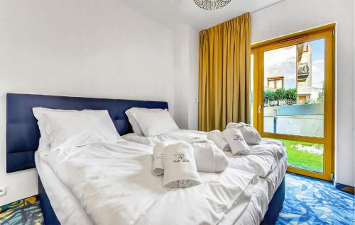 a bedroom with a large white bed with towels on it at 2 Bedroom Cozy Apartment In Hel in Hel