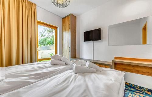 uma grande cama branca num quarto com uma televisão em 2 Bedroom Cozy Apartment In Hel em Hel