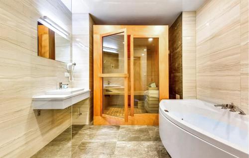 a bathroom with a tub and a sink and a mirror at 2 Bedroom Cozy Apartment In Hel in Hel