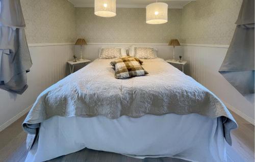 een slaapkamer met een bed met een geruite kussen erop bij Amazing Home In ngelholm With Kitchen in Ängelholm