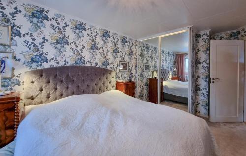 a bedroom with a bed with blue floral wallpaper at Nice Home In Alingss With Lake View in Alingsås