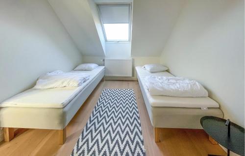 - 2 lits dans une petite chambre avec un tapis dans l'établissement Gorgeous Home In Torekov With Sauna, à Torekov