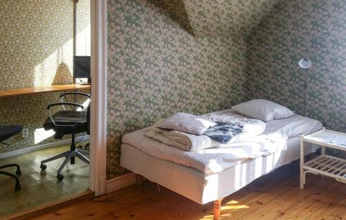 um quarto com uma cama com uma cadeira e uma secretária em 3 Bedroom Beautiful Home In Vstervik em Västervik