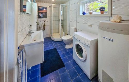 a bathroom with a washing machine and a sink at Nice Home In Stavern With Kitchen in Stavern
