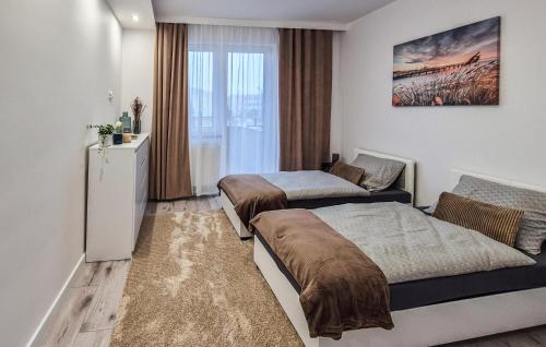um quarto com 2 camas e um frigorífico em Nice Home In Kamien Pomorski With Kitchen em Kamień Pomorski