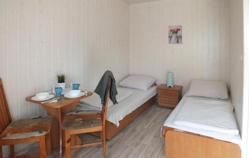 a small room with two beds and a table and a tableablish at Pet Friendly Home In Miedzyzdroje With Kitchen in Międzyzdroje