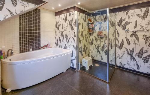 La salle de bains est pourvue d'une grande baignoire blanche et d'une douche. dans l'établissement Beautiful Home In Ulricehamn With Lake View, à Bottnaryd